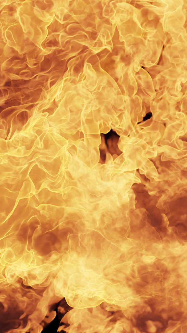 Intenst udbrud af orange og gule flammer på sort baggrund