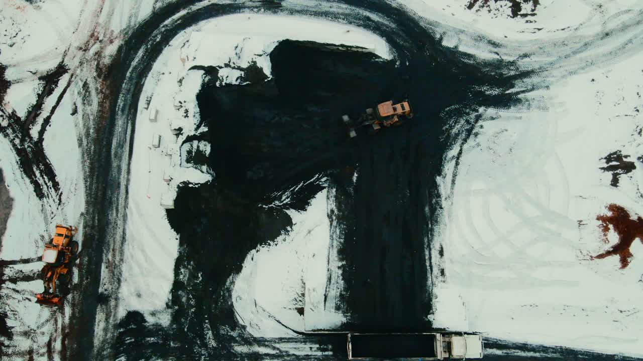 toma aérea del manejo eficiente de la suciedad negra en un aserradero canadiense en invierno: semirremolque de carga de cargadora de ruedas