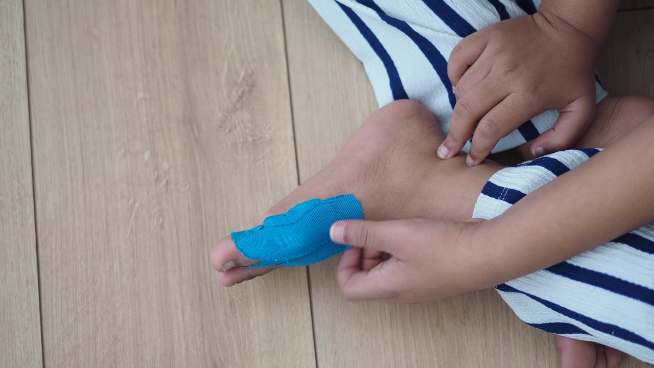 Close-up of Child's Foot with Blue Bandage on Toe