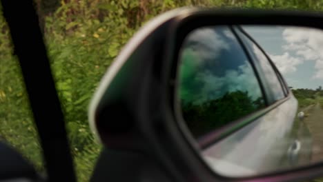 Blick-Auf-Die-Straße-Im-Seitenspiegel-Eines-Fahrenden-Autos