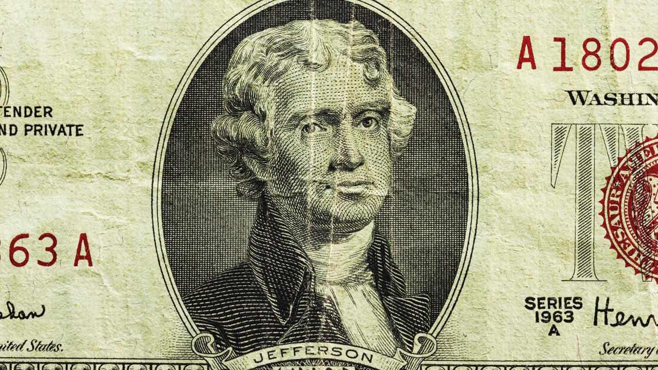 Close pan of a worn 1963 U.S. two dollar note with red seal, visible creases and aged paper