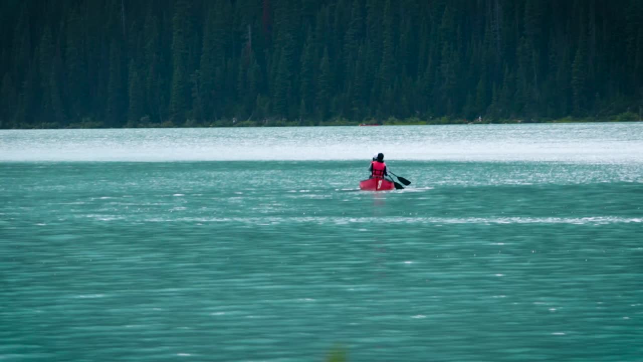 평화로운 호수 에서 카누 를 타고 있는 사랑스러운 부부