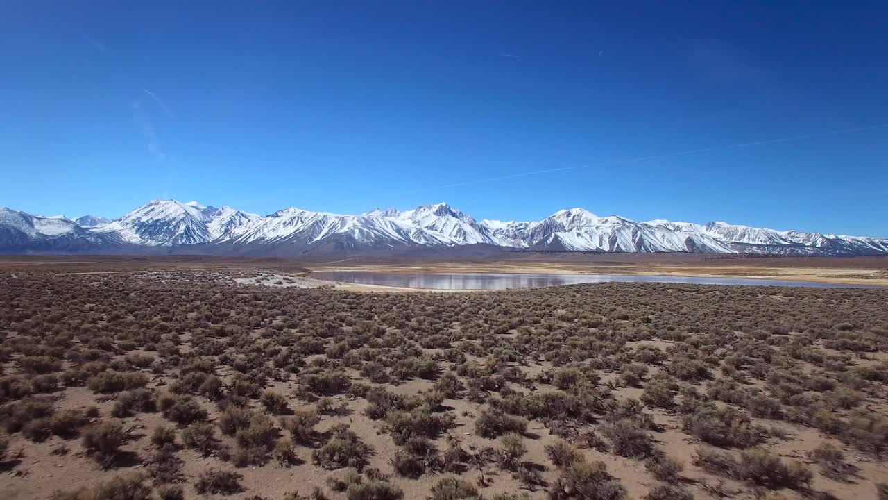 una antena sobre una llanura geotérmica en las montañas de sierra nevada cerca de mammoth california revela un lago de montaña