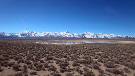 una antena sobre una llanura geotérmica en las montañas de sierra nevada cerca de mammoth california revela un lago de montaña