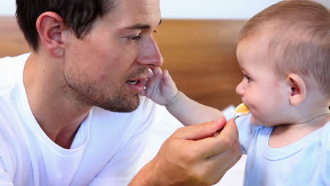 happy father feeding his baby son