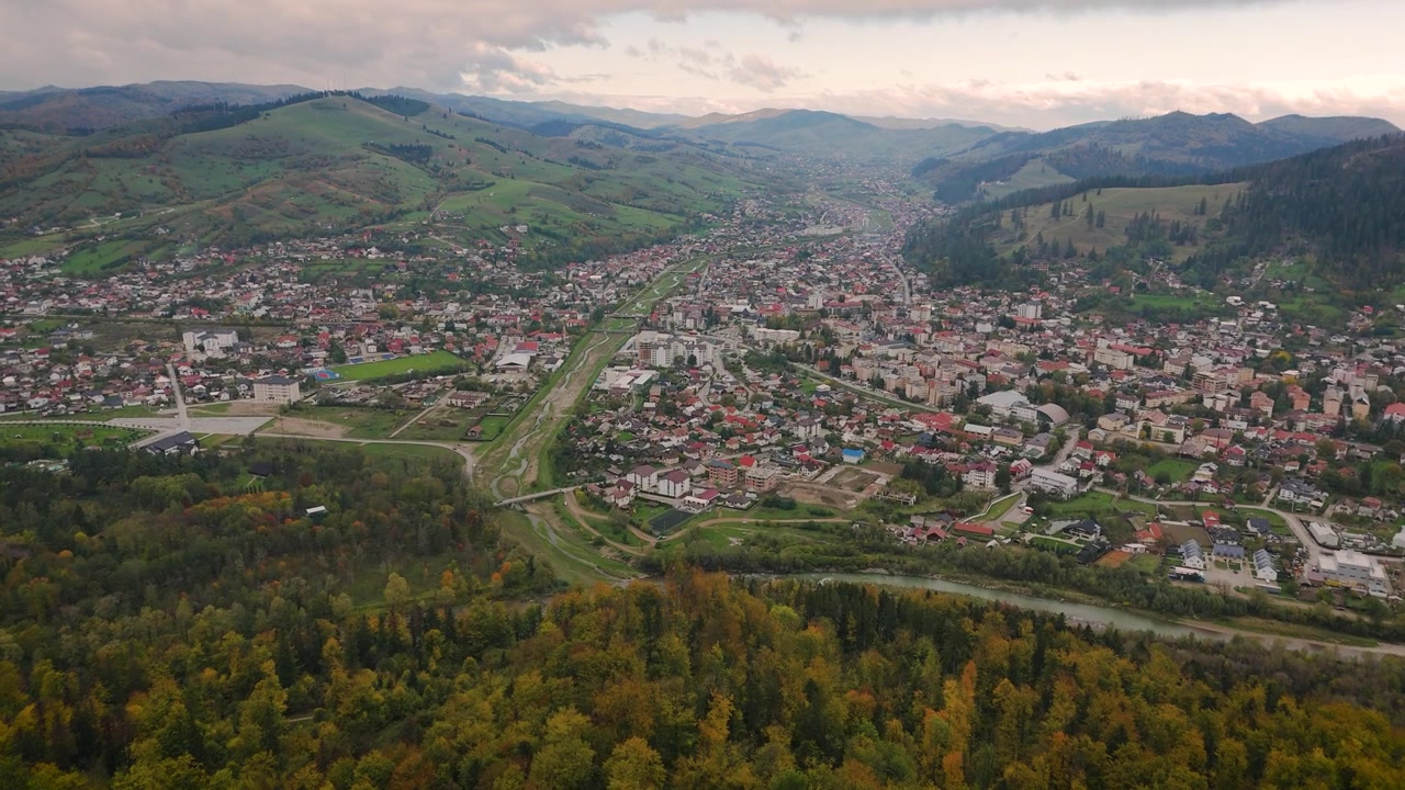 Riprese aeree con drone di Gura Humorului, Suceava, che mostrano i colori autunnali della foresta circostante e la città incastonata tra colline coperte di vegetazione