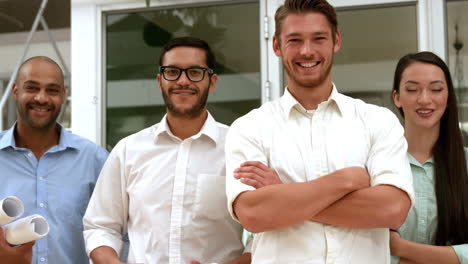 equipo de negocios casual sonriendo a la cámara con los brazos cruzados