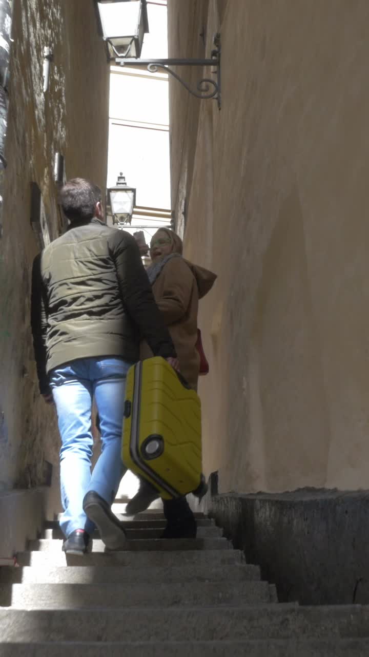 People walking up stairs with suitcase