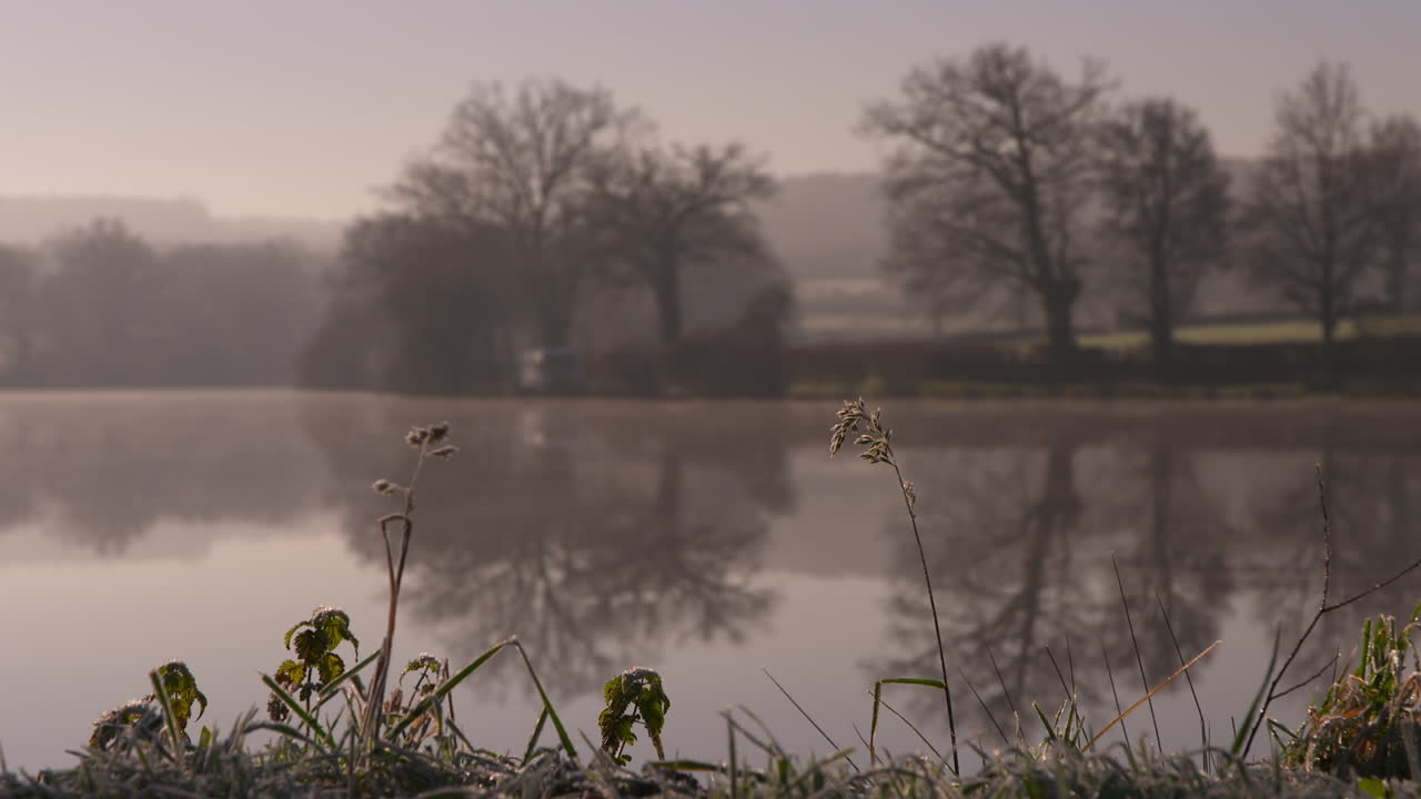 impresionante toma de un lago cristalino y tranquilo temprano en la mañana, con enfoque