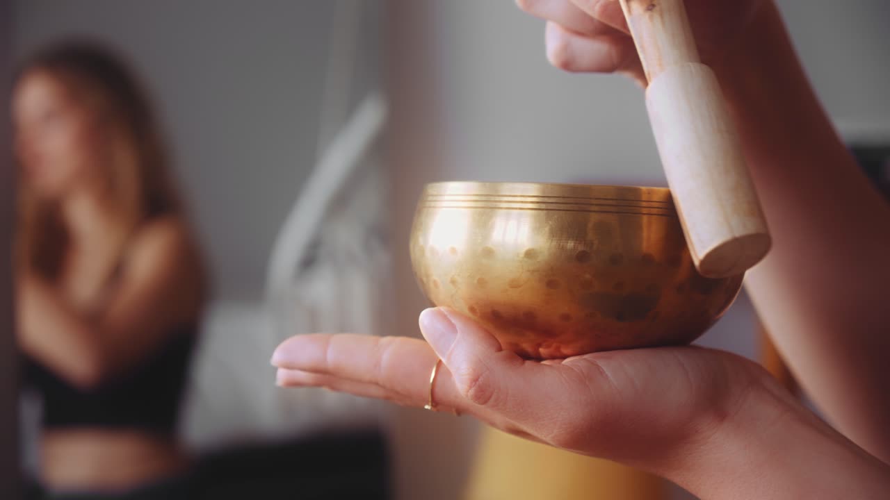 cerrar las manos de la mujer usando un cuenco tibetano