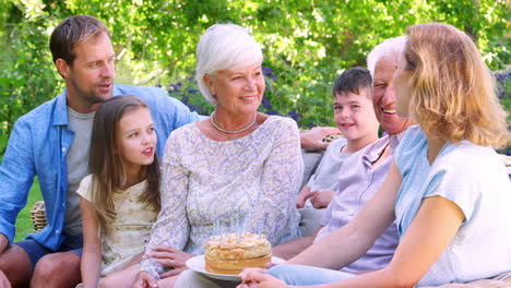 Three-generation-family-celebrating-a-birthday-in-the-garden