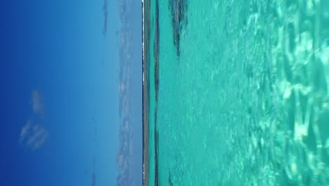 Low-flyover-above-clear-shallow-water-and-coral-reef-near-Mare-Island-in-New-Caledonia