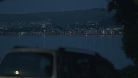 night view of a waterfront town with city lights reflecting on the water