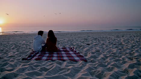 couple enjoying a sunset picnic on the beach