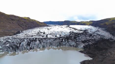 solheimajokull glacier meets dramatic volcanic landscape creating stark contrast