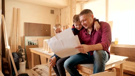 family, carpentry, woodwork and people concept. father teaches son carpentry.