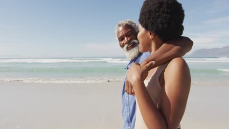 Glückliches-Afroamerikanisches-Paar,-Das-Am-Sonnigen-Strand-Spaziert-Und-Sich-Umarmt