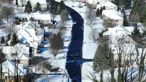 Aerial-shot-of-a-singular-vehicle-driving-down-a-neighborhood-street