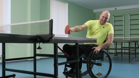 a man in a wheelchair plays ping pong. people with disabilities play table tennis. rehabilitation of the disabled. sport.