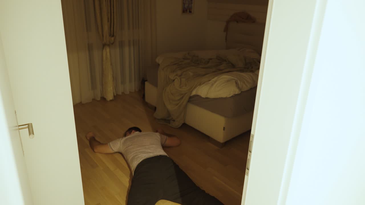 A cat approaches its owner lying motionless on the floor, showing the strong bond between pets and humans and their instinctive care and curiosity