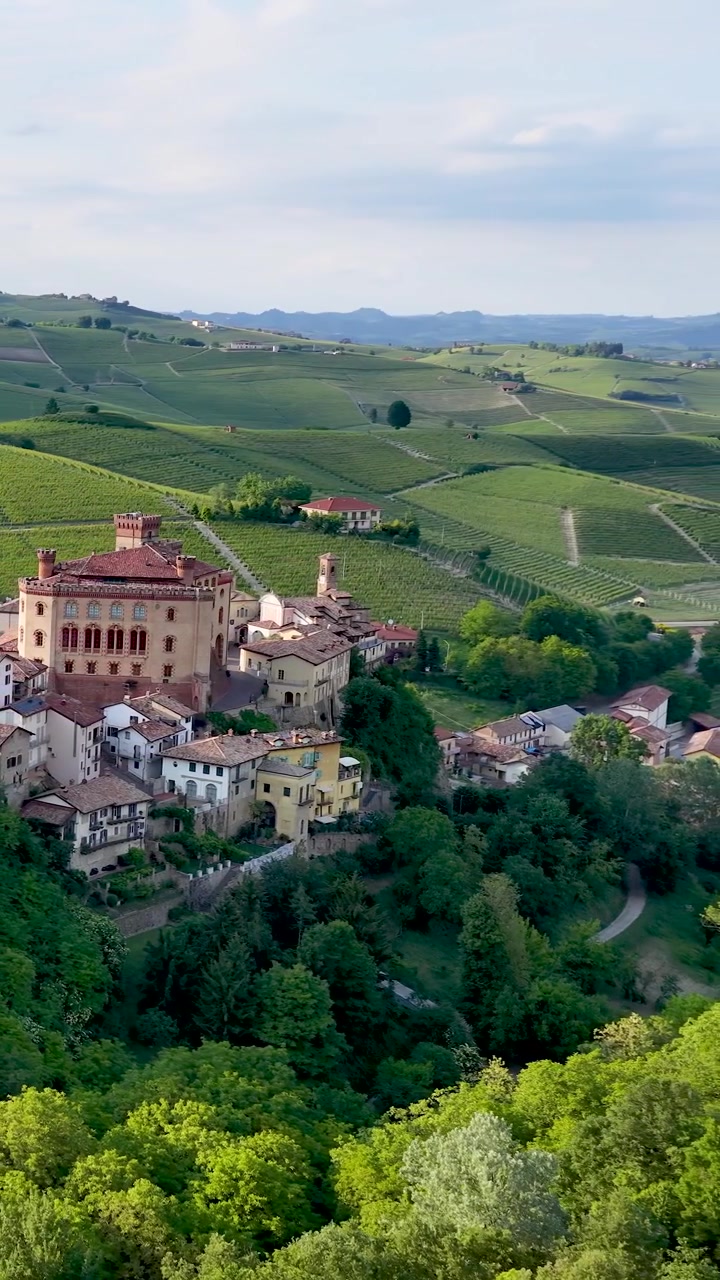 Vista panoramica di un borgo storico italiano con vigneti in Piemonte