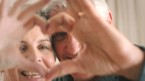 Senior-couple-doing-a-heart-shape-with-their-hands