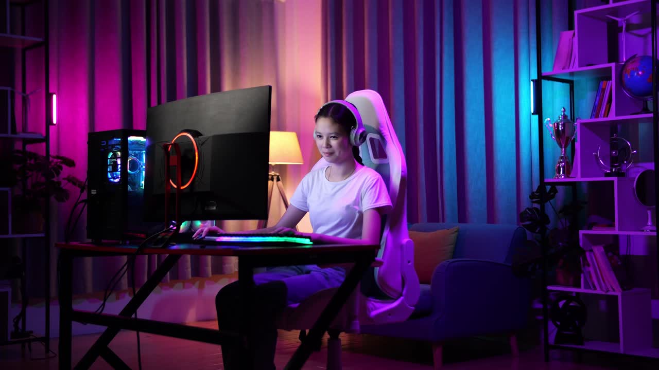 una adolescente asiática emocionada jugando videojuegos en la computadora