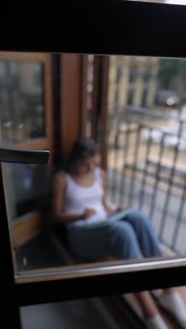 woman drawing on a tablet on a balcony