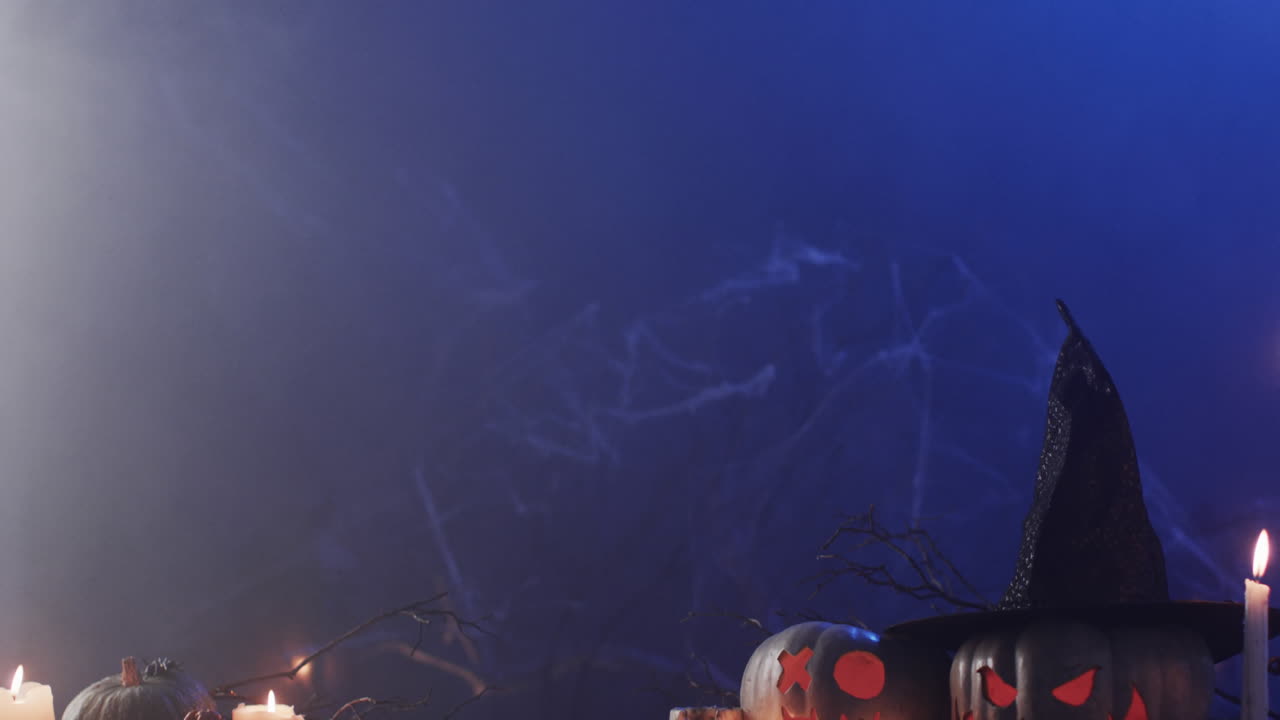 video de calabazas talladas de halloween, velas y humo con espacio de copia sobre fondo púrpura