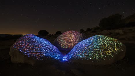 captivating nighttime display of colorful patterns on rocks under a starry sky: an enchanting contrast between bright and warm hues