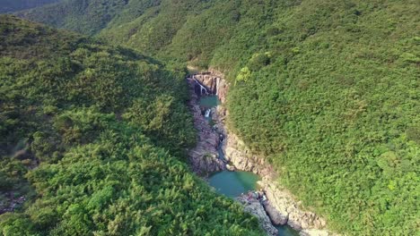 sai kung famous rock pools and waterfall as seen from bird's eye view, forward aerial shot tilting down