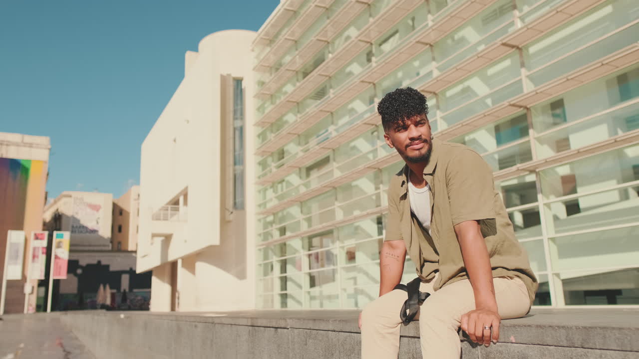 Man sitting in front of a modern building