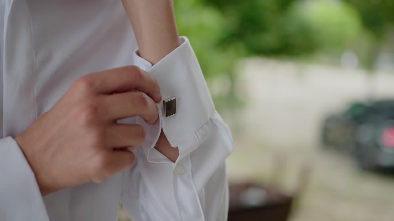 Man Buttoning Cufflinks on White Shirt