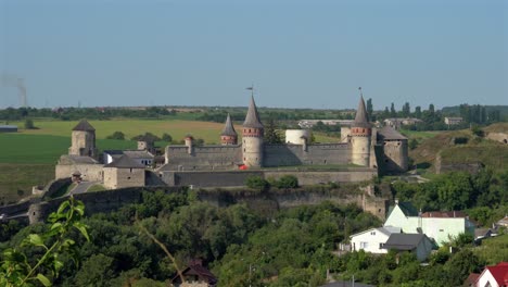 aerial view forward towards kamianets podilskyi's old castle on a sunny day with blue skies no clouds.