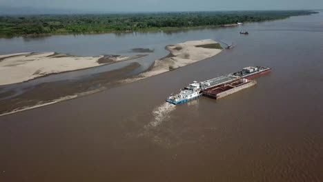 vista aérea de un buque de carga cargando y transportando una plataforma en el río magdalena en colombia en un día soleado