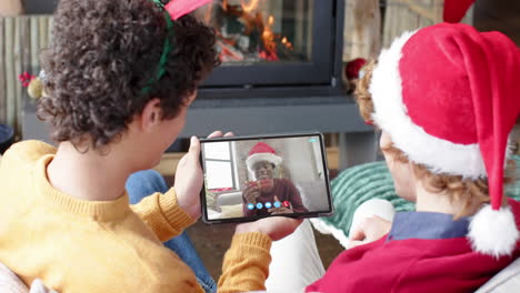 Tres-Amigos-Varones-Felices-Y-Diversos-Teniendo-Videollamadas-Navideñas-Con-Tabletas,-Cámara-Lenta