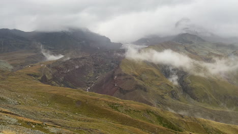 mountaintop view of stepantsminda, georgia during cloudy rainstorm