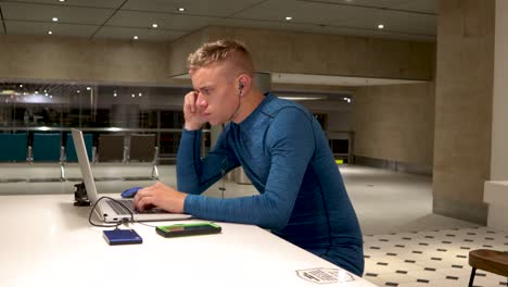 A-young-man-working-from-his-laptop-at-a-table-in-Changi-international-airport