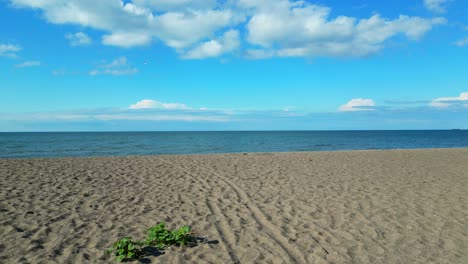 pov reveals a small sandy, empty beach approaching the shoreline with horizon