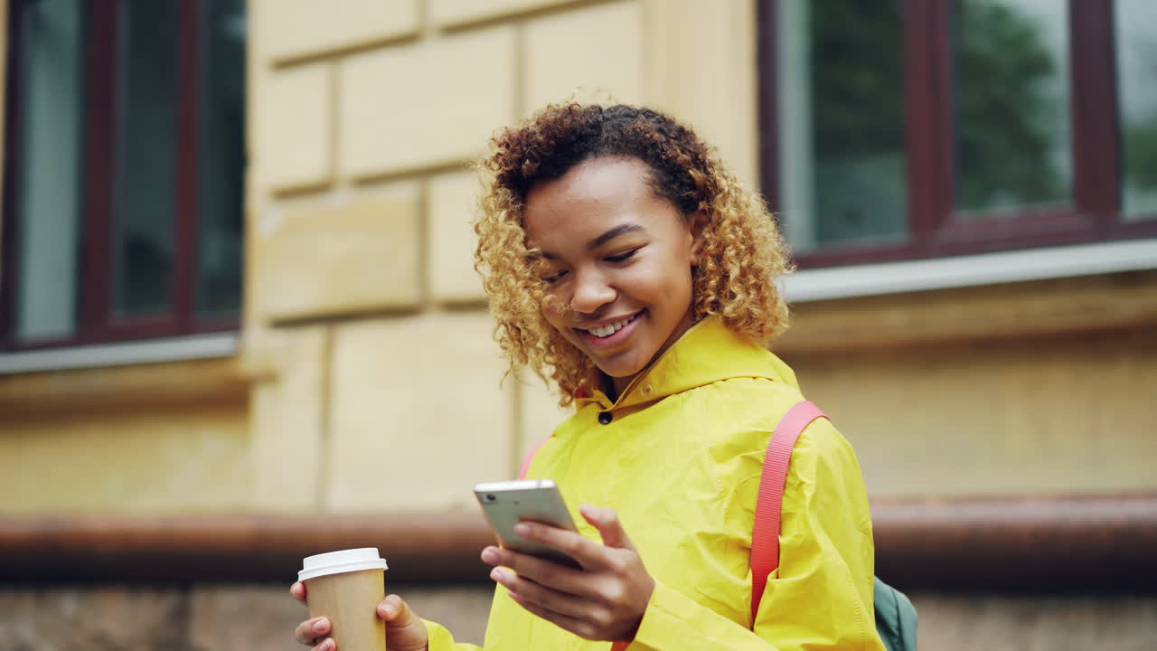 Young woman using a phone in the rain