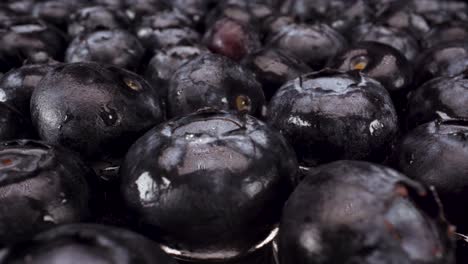 Vista-Macro-Pasando-Por-Encima-De-Girar-Arándanos-En-Vidrio,-Toma-4k-De-Fruta-Fresca-Saludable,-Dieta-Nutricional,-Acai-De-Arándanos