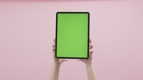 tableta digital con pantalla de teclas cromadas y que se muestra en el fondo rosado.