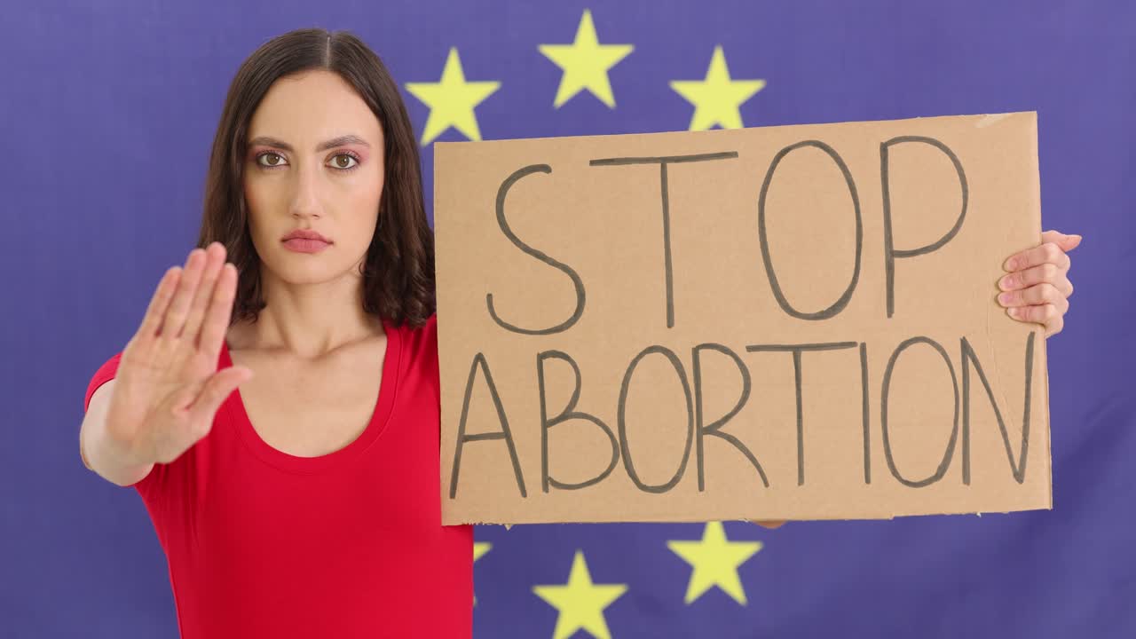 Woman Protesting Abortion with 'Stop Abortion' Sign Against European Union Flag