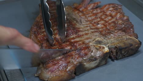 primer plano de cortar un bistec de chuleta de cerdo a la parrilla