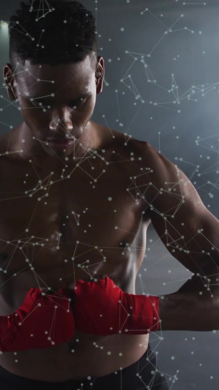 Video verticale: Pugile che srotola le bende rosse, avvolgendo i pugni con un'overlay a punti, preparandosi per la boxe.