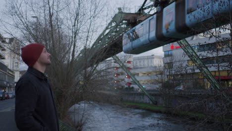 A-Traveler-in-wonder-watching-Wuppertal's-suspended-railway-system,-Germany