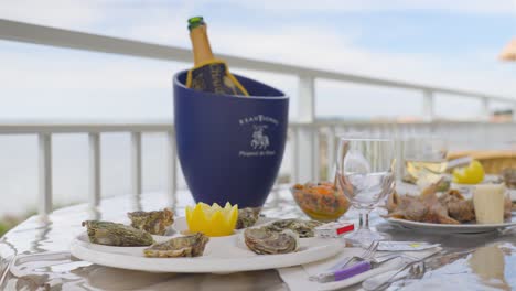 On-the-table-at-the-restaurant,-there-is-a-display-of-oysters,-accompanied-by-lemon-and-a-bottle-of-champagne