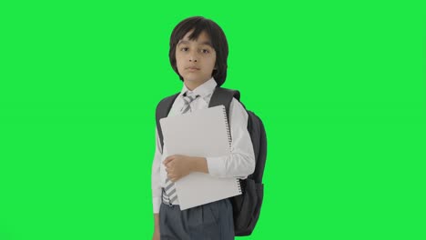 retrato de un niño de escuela indio confiado de pie con libros pantalla verde