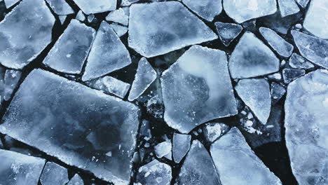 drone shot panning around showing huge chunks of frozen ice in lake michigan, looking straight down