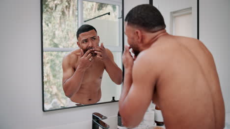 man grooming in the bathroom mirror